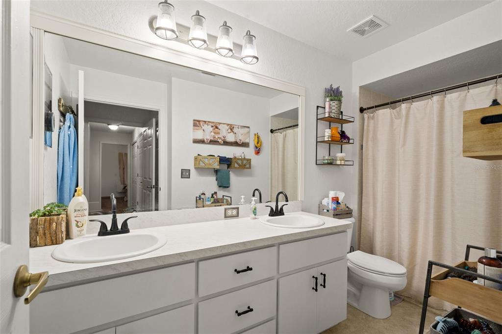 8159 Sturbridge Court, Unit 8159 Weeki Wachee, FL 34613 - Photo 13 of 27 a bathroom with a double vanity sink mirror and toilet