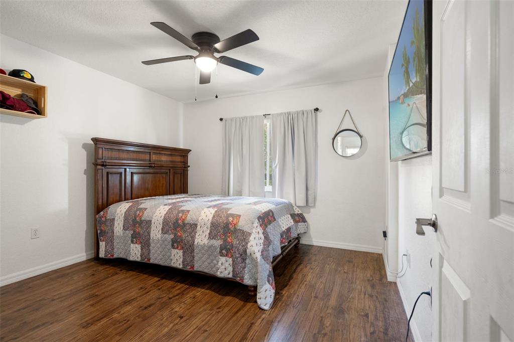 8159 Sturbridge Court, Unit 8159 Weeki Wachee, FL 34613 - Photo 14 of 27 a bedroom with a bed and wooden floor