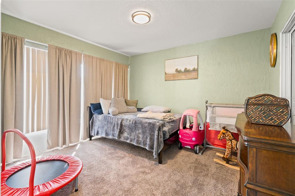 8159 Sturbridge Court, Unit 8159 Weeki Wachee, FL 34613 - Photo 17 of 27 a bedroom with a bed and a chandelier