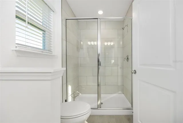 a bathroom with a shower a toilet and a shower