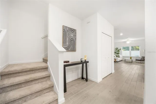 a view of a hallway with wooden floor and a bathroom