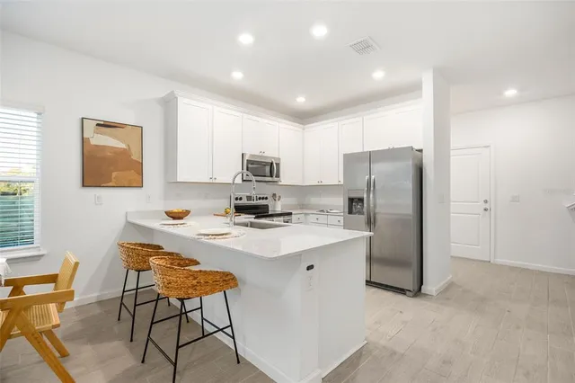 a kitchen with stainless steel appliances a refrigerator and a stove top oven
