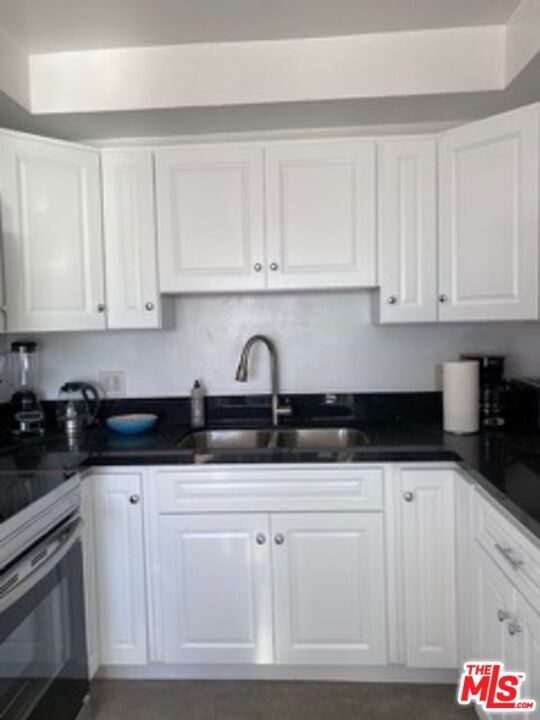 2609 Ocean Front Walk Venice, CA 90291 - Photo 11 of 17 a kitchen with granite countertop white cabinets and sink