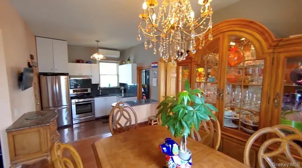 a living room with furniture a chandelier and a floor to ceiling window