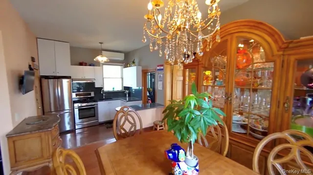 a living room with furniture a chandelier and a floor to ceiling window
