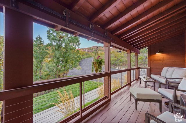 5878 Snowbasin Road Huntsville, UT 84317 - Photo 45 of 90 Covered outdoor deck with exposed wood beam ceiling, wood-finish flooring, and cable railing system