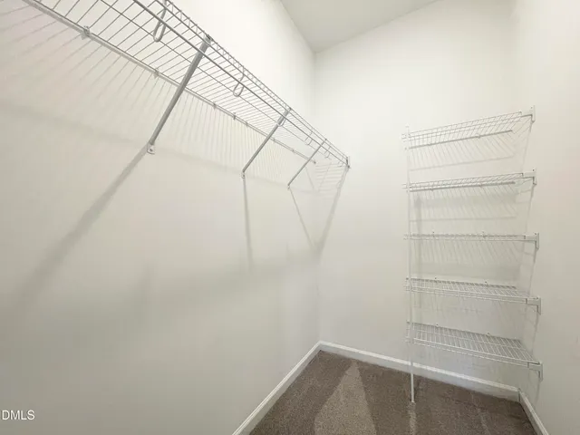 a view of walk in closet with empty racks