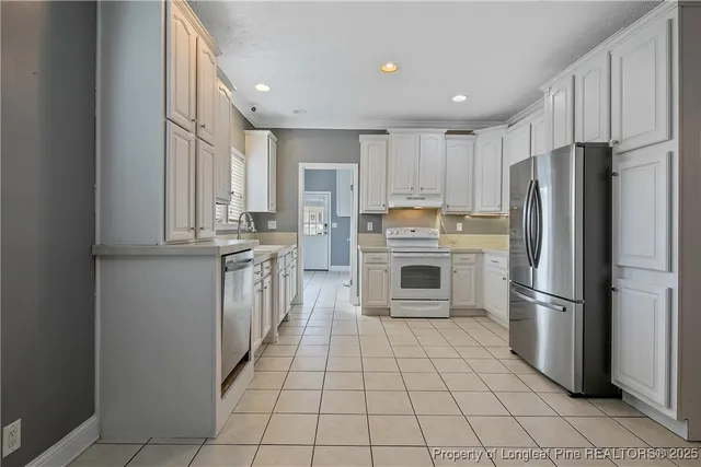 a kitchen with stainless steel appliances granite countertop a refrigerator and a stove top oven