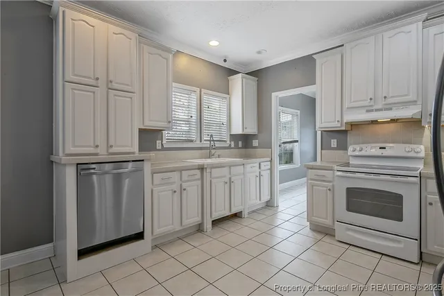 a kitchen with white cabinets and white appliances