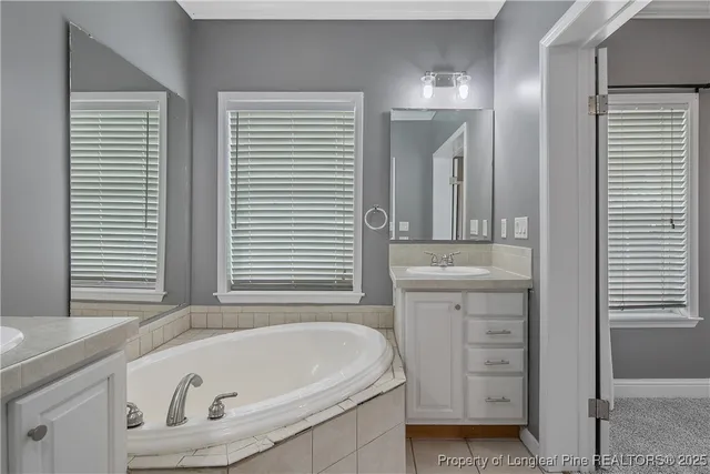 a bathroom with a tub a sink and a window
