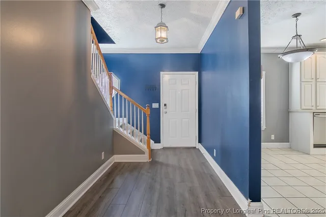 a view of a hallway with wooden floor and staircase