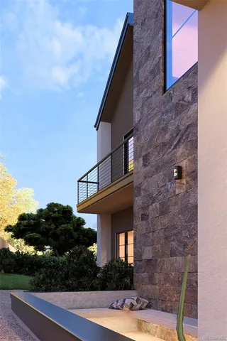 a front view of a house with plants and large tree