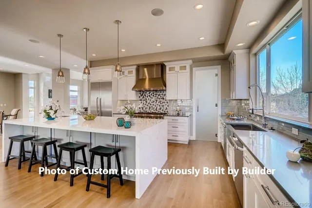 a large kitchen with kitchen island a island a stove a sink a counter space and dining table