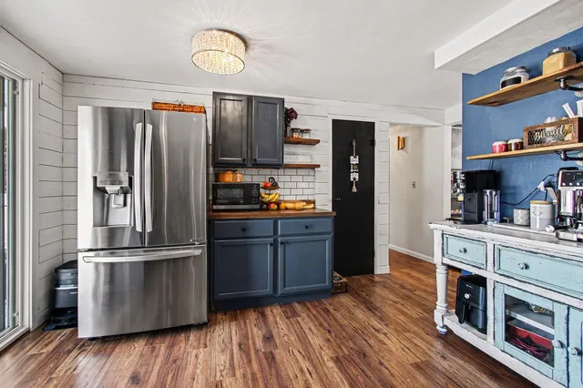 a kitchen with stainless steel appliances granite countertop a refrigerator stove and wooden floor