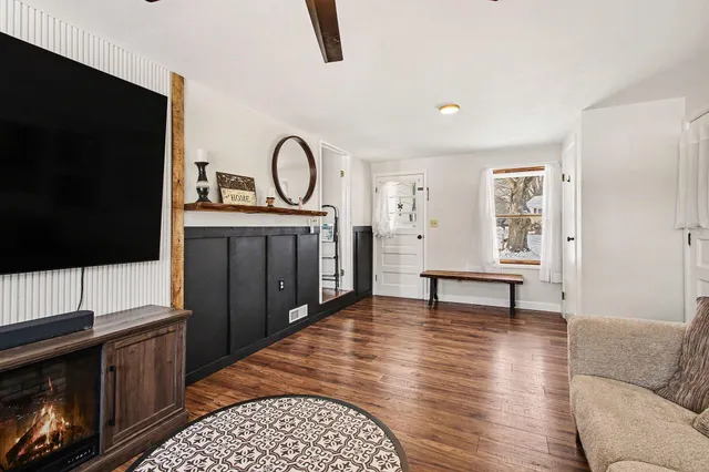 a living room with furniture a flat screen tv and kitchen view