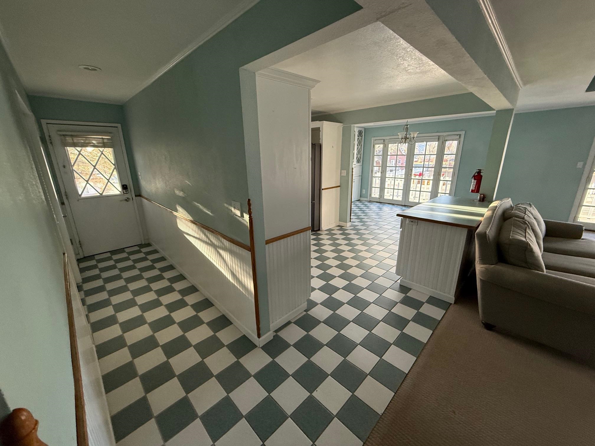323 Main Street Bridgeport, CA 93517 - Photo 9 of 38 a living room with a black white checkered floor with a gaming machine and dining chair