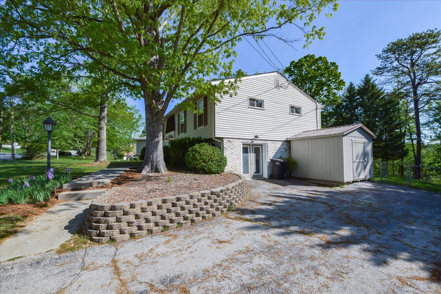 2947 Purple Finch Road Roanoke, VA 24018 - Photo 22 of 31 a view of a white house with a yard plants and large tree