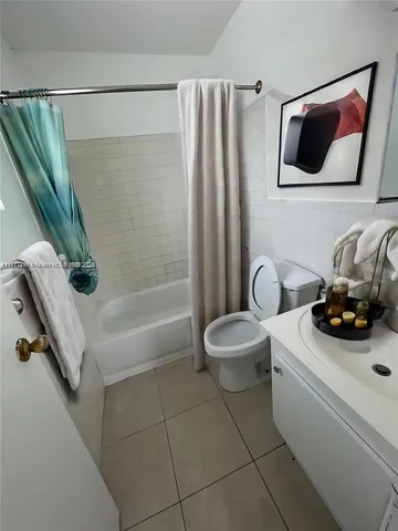 a bathroom with a sink a toilet and a shower curtain