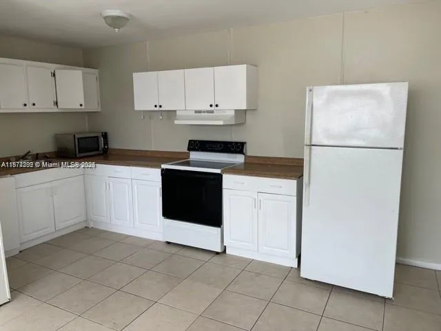 a kitchen with white cabinets and white appliances