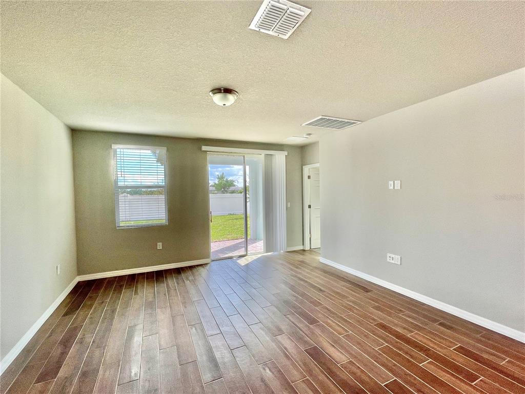 5232 Stephs Field Street St. Cloud, FL 34771 - Photo 13 of 43 an empty room with wooden floor and windows