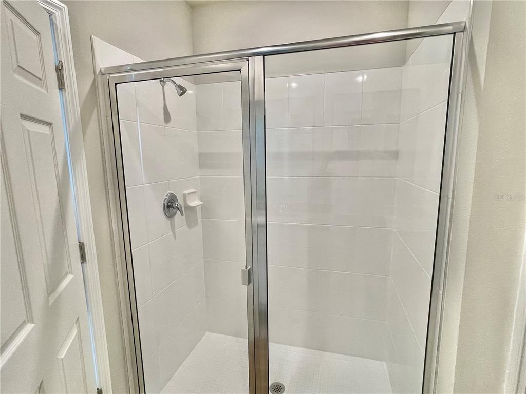 5232 Stephs Field Street St. Cloud, FL 34771 - Photo 22 of 43 a bathroom with a glass shower door