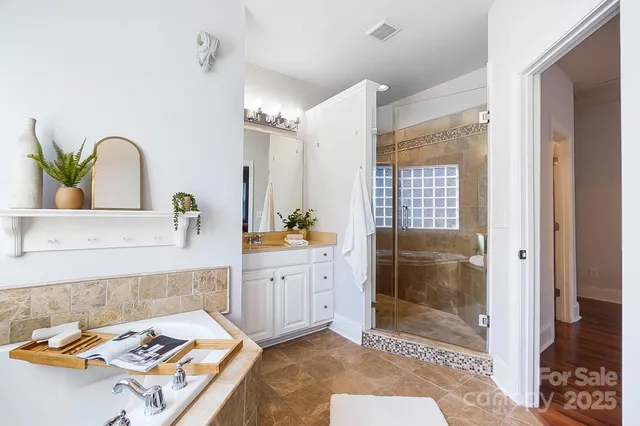 a spacious bathroom with a granite countertop sink a mirror and shower