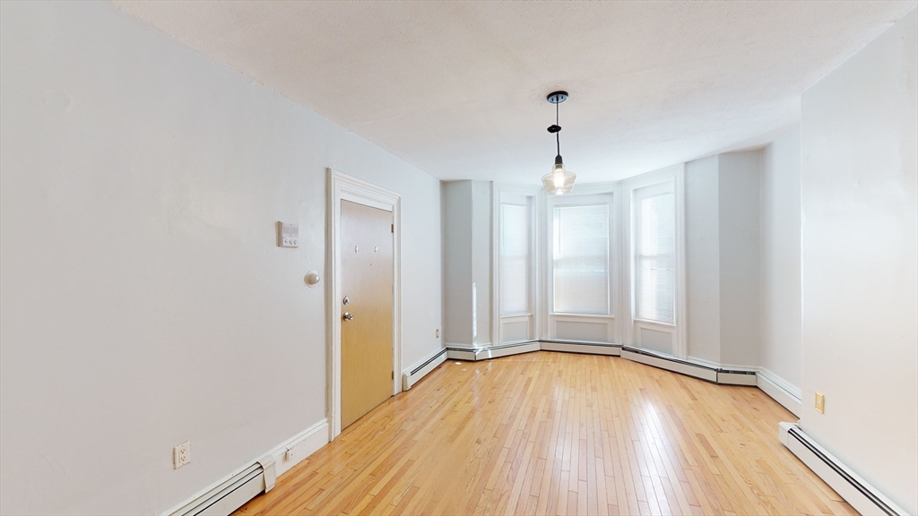 2999 Washington Street, Unit 1 Boston, MA 02119 - Photo 10 of 18 a view of empty room with wooden floor and fan