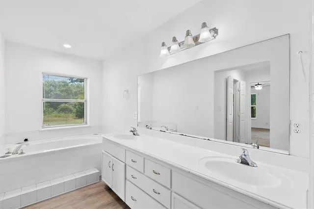 a bathroom with 2 sink tub and a mirror