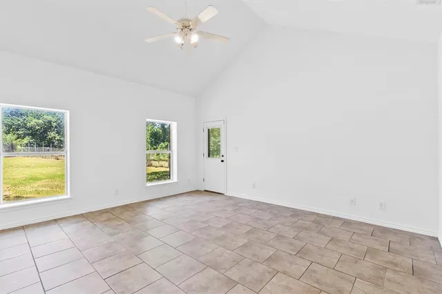 an empty room with windows and fan