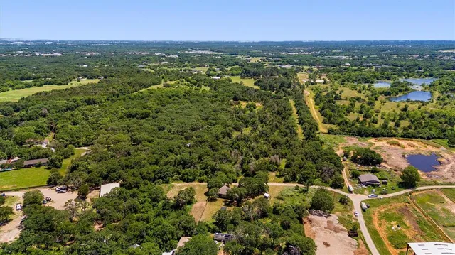 an aerial view of residential houses with outdoor space and trees