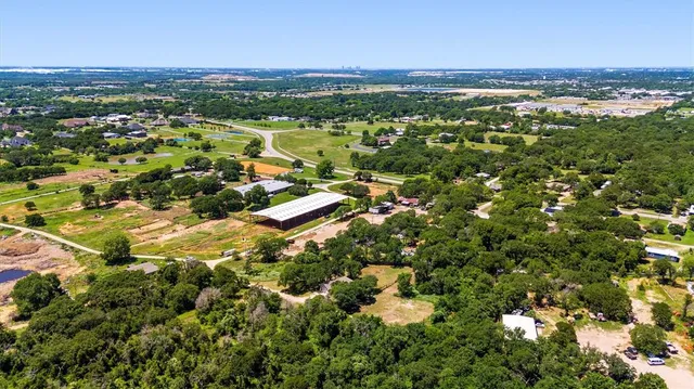 an aerial view of residential houses with outdoor space and trees