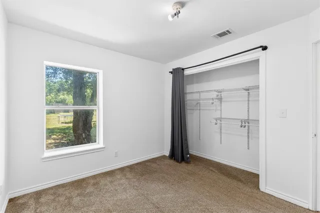 an empty room with windows and closet