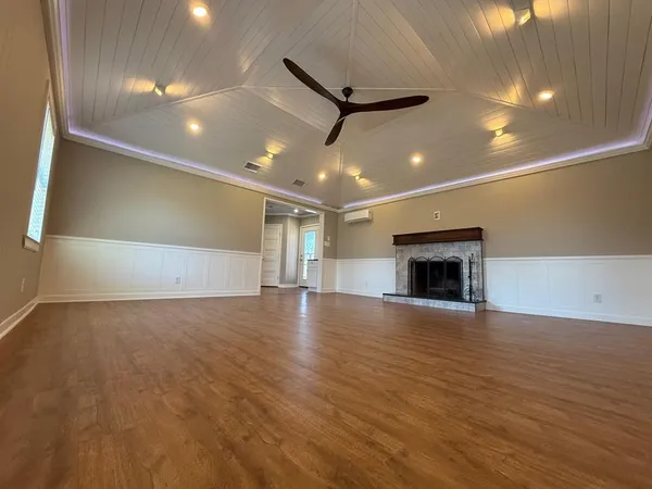 a view of empty room with wooden floor and fireplace