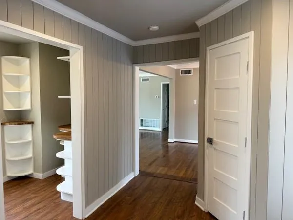 a view of a hallway with wooden floor and bathroom view