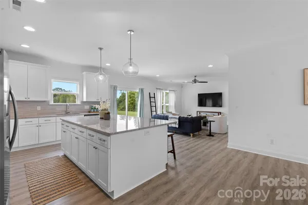 a kitchen with stainless steel appliances kitchen island granite countertop a sink and a stove top oven