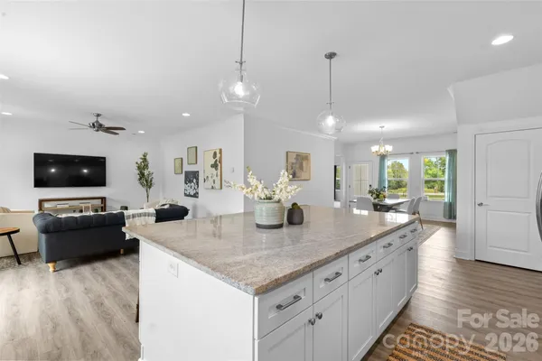 a view of living room with kitchen island furniture and flat screen tv