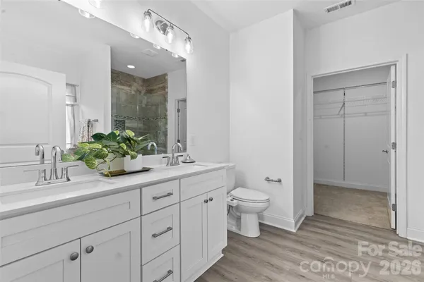 a bathroom with a double vanity sink toilet and shower