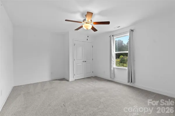 a view of empty room with ceiling fan