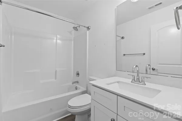 a bathroom with a granite countertop sink a toilet and shower