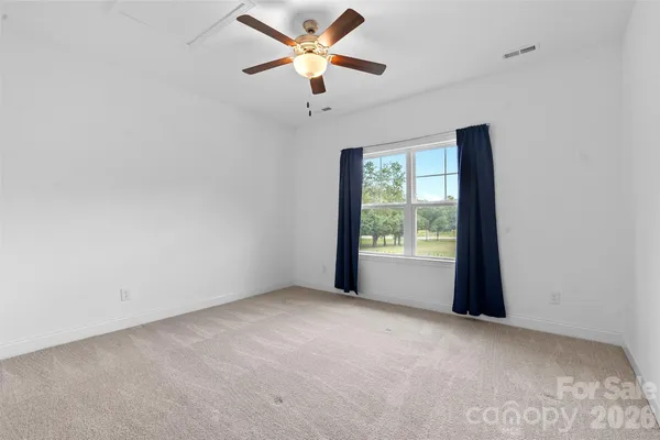 a view of a room with a ceiling fan and a window