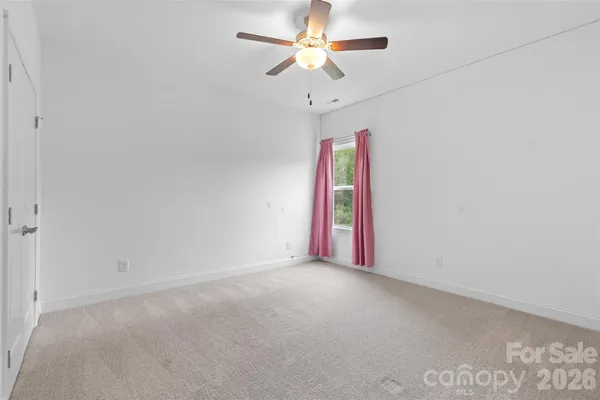 a view of a room with a ceiling fan and a shower