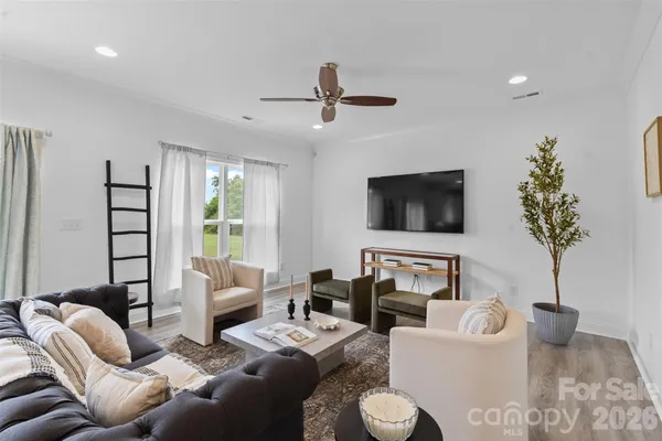 a living room with furniture a flat screen tv and a potted plant