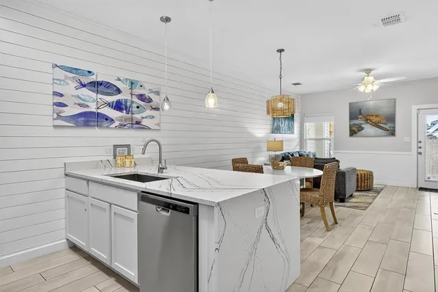 a kitchen with a sink dishwasher and a stove with wooden floor