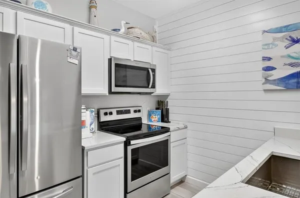 a kitchen with stainless steel appliances a stove microwave and refrigerator