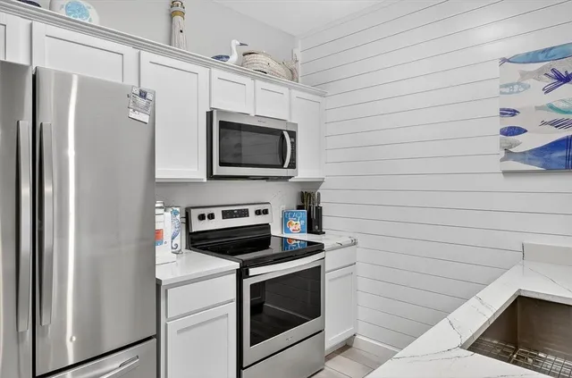 a kitchen with stainless steel appliances a stove microwave and refrigerator