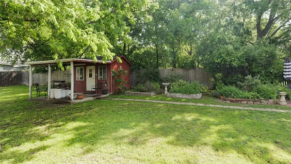 a view of a backyard with a garden and entertaining space