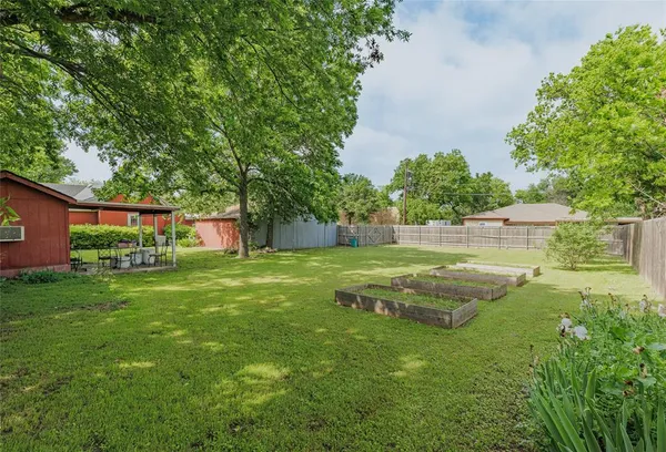 a view of an house with backyard and trees