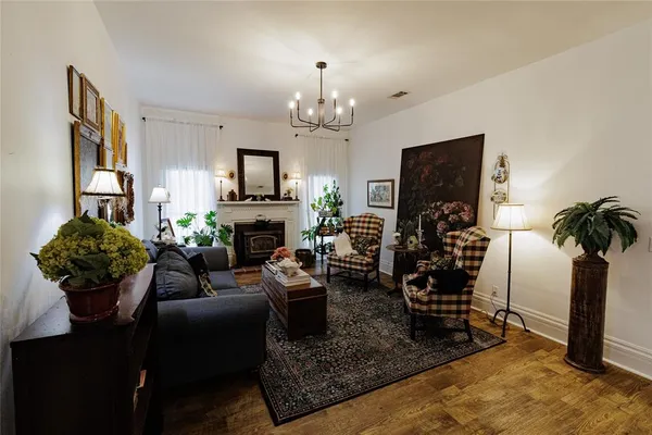 a living room with furniture a chandelier and a flat screen tv