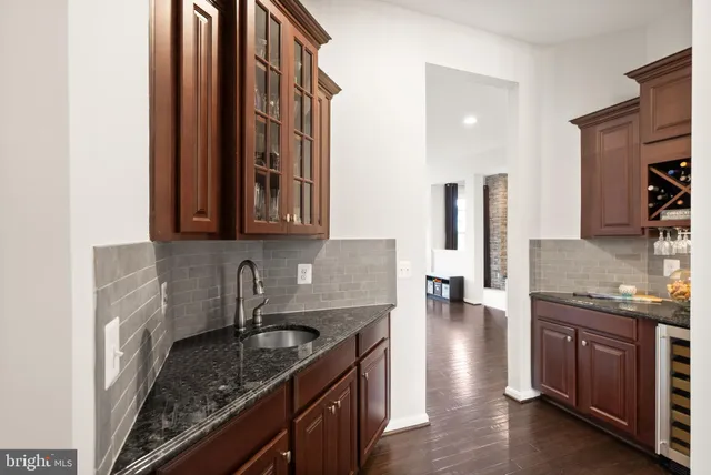 a kitchen with granite countertop a sink cabinets and stainless steel appliances