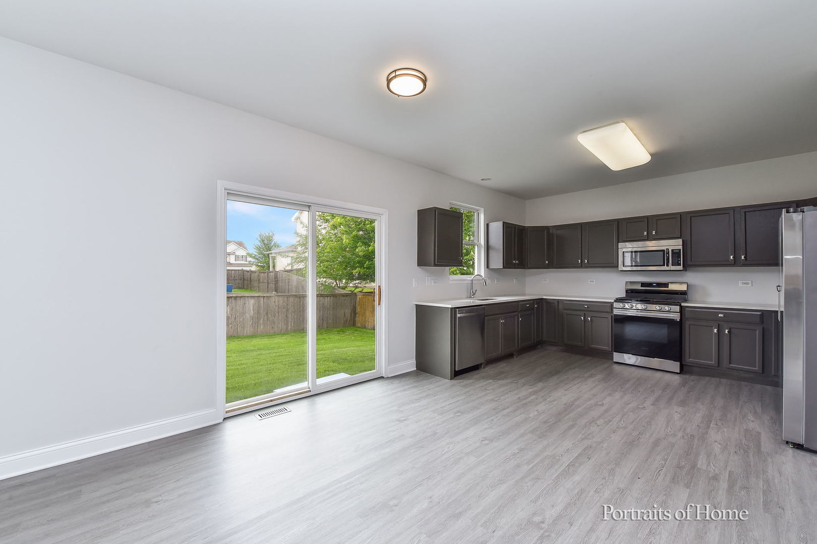 1412 Colaric Court Joliet, IL 60431 - Photo 9 of 25 a large kitchen with a wooden floor and stainless steel appliances